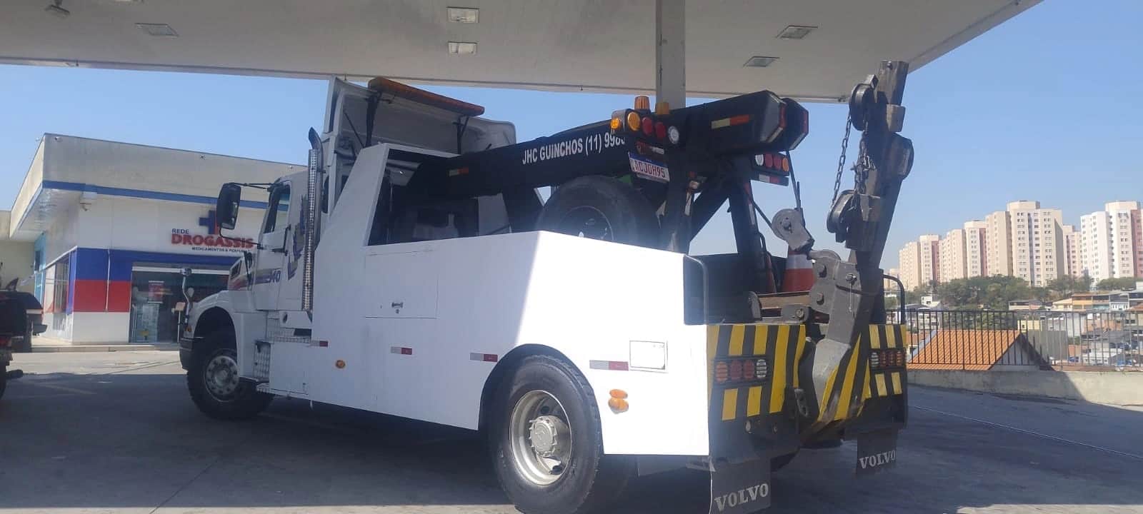 Traseira do guincho pesado da JHC, com a lança estendida e o gancho de içamento à mostra.